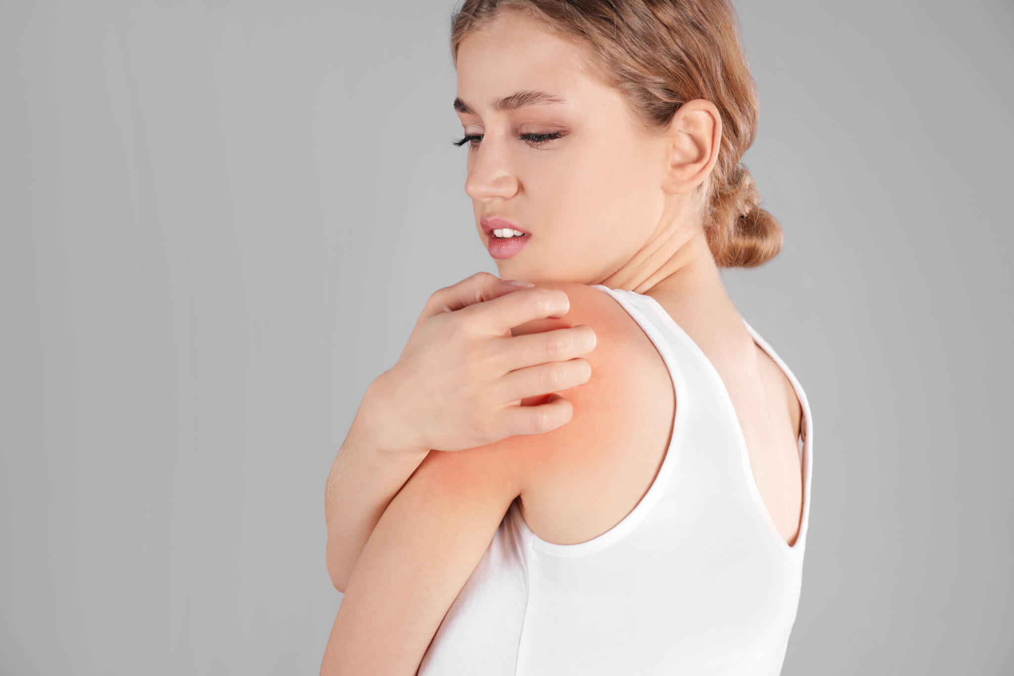 Woman,Scratching,Shoulder,On,Grey,Background.,Allergy,Symptoms